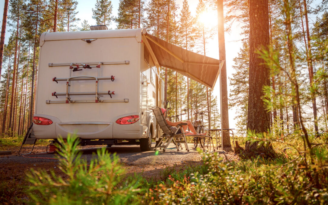 Someone sits outside an RV in the summer time. This summer RV checklist will prepare you for summer fun