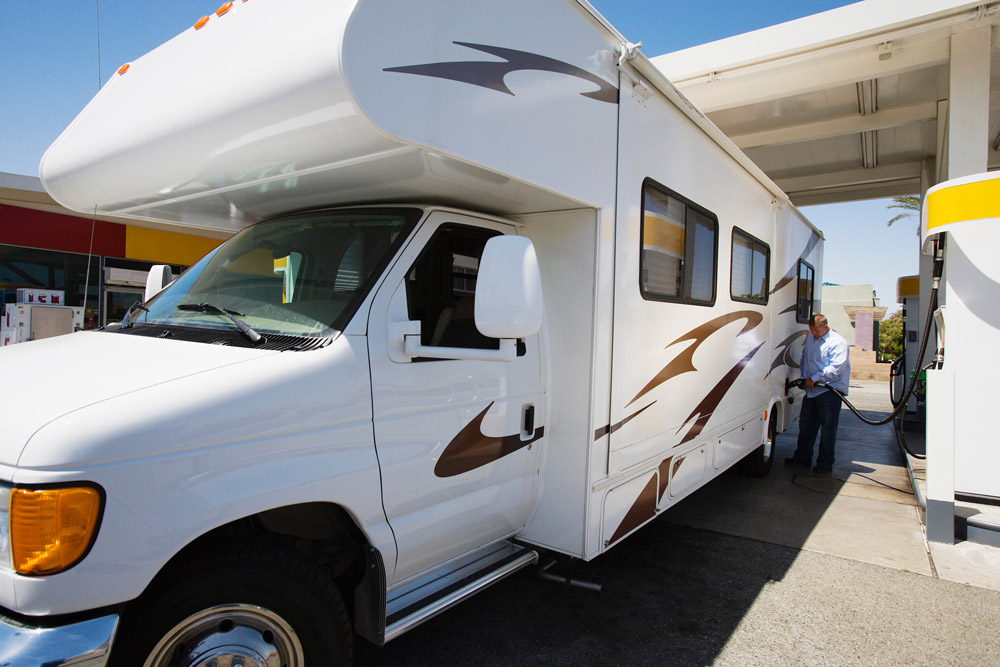 A man fills up his Class C RV with fuel. Staying fueled is important for RV hurricane safety