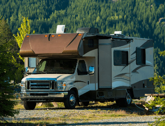 Class C RV parked in the woods
